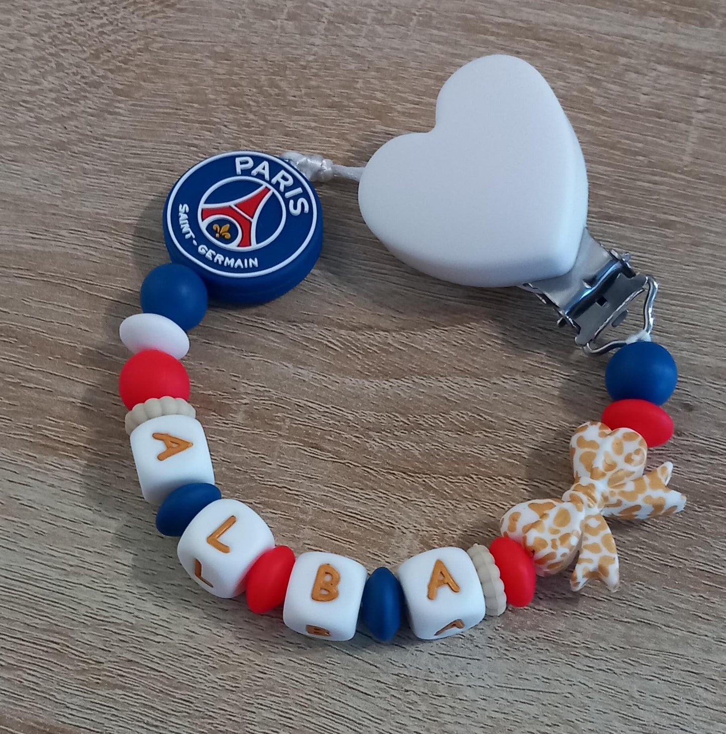 Attache tétine personnalisée Paris Saint Germain. Modèle Alba PSG pour fille. Cadeau naissance et jeunes parents. Création française.