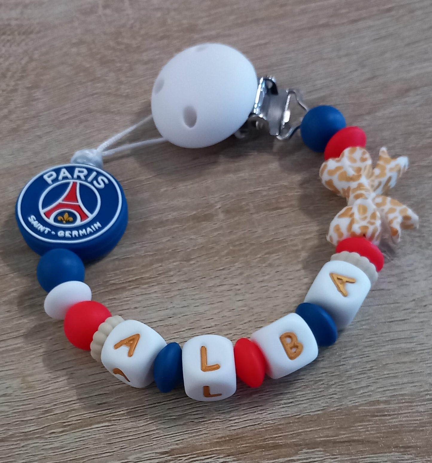 Attache tétine personnalisée Paris Saint Germain. Modèle Alba PSG pour fille. Cadeau naissance et jeunes parents. Création française.