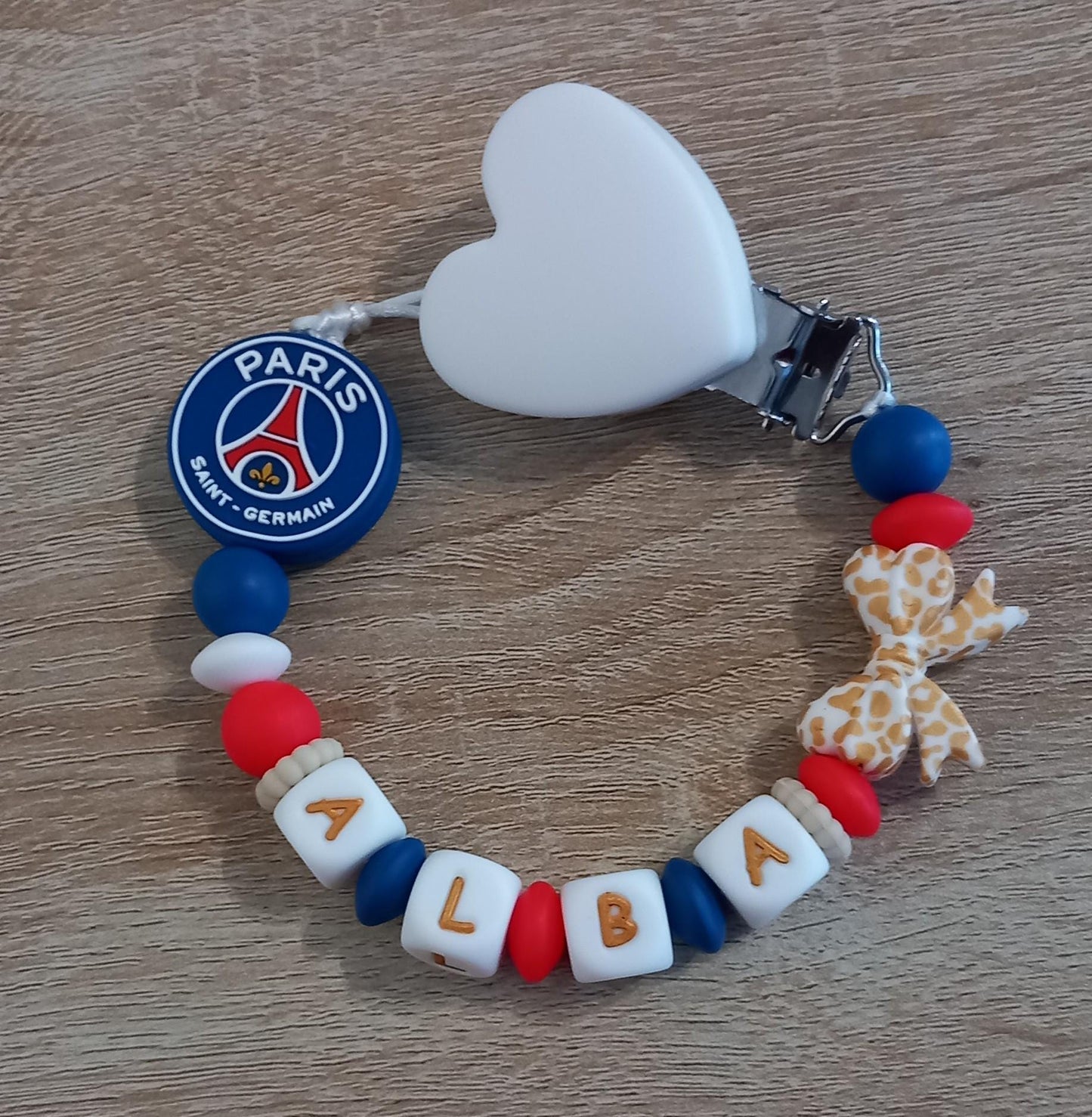 Attache tétine personnalisée Paris Saint Germain. Modèle Alba PSG pour fille. Cadeau naissance et jeunes parents. Création française.