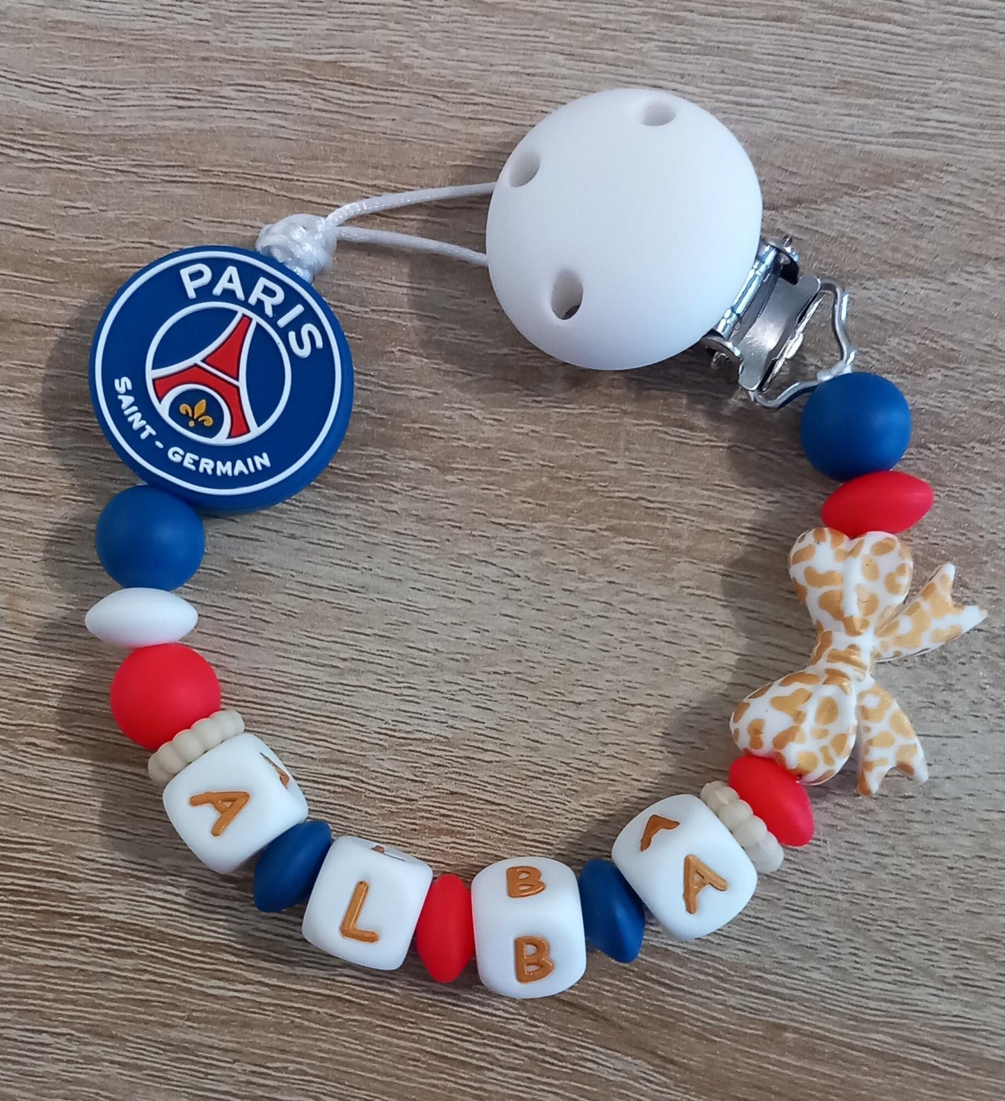 Attache tétine personnalisée Paris Saint Germain. Modèle Alba PSG pour fille. Cadeau naissance et jeunes parents. Création française.