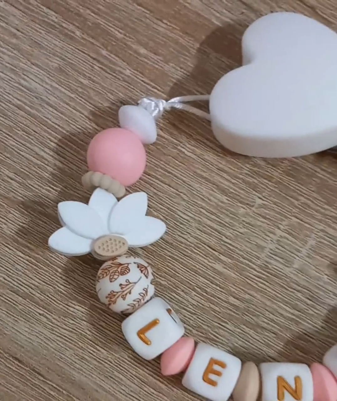 Attache tétine fille personnalisée, feuilles de lotus blanches, perles imprimées floral, clip silicone coeur.  
Idée cadeau naissance, anniversaire, babyshower, jeunes parents. Attache tétine girly.